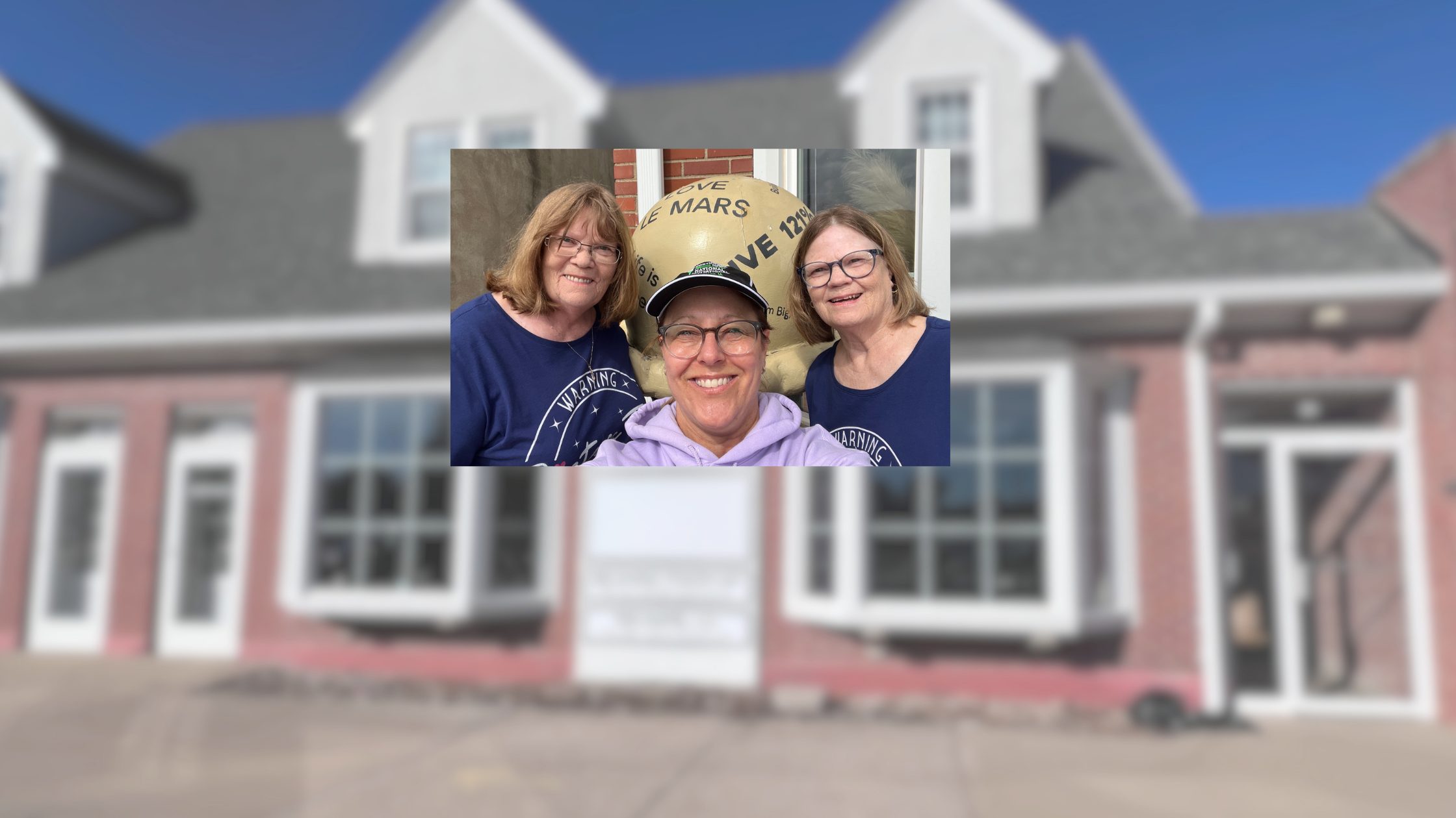 Julie Hurt smiles with two sisters visiting Le Mars, Iowa, as they take a selfie in front of the downtown ice cream cone sculpture outside the CENTURY 21 ProLink office.