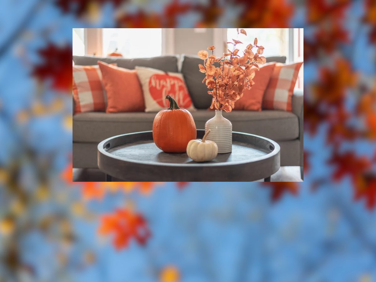 Fall-decorated living room with pumpkins, autumn pillows, and orange foliage for a blog about buying or selling a home in Le Mars.
